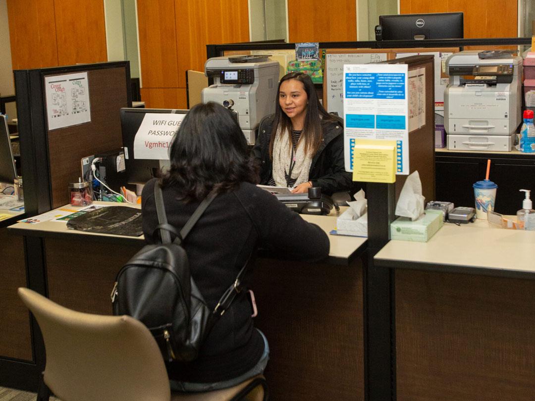 Dos mujeres sentadas frente a frente en un mostrador hablando