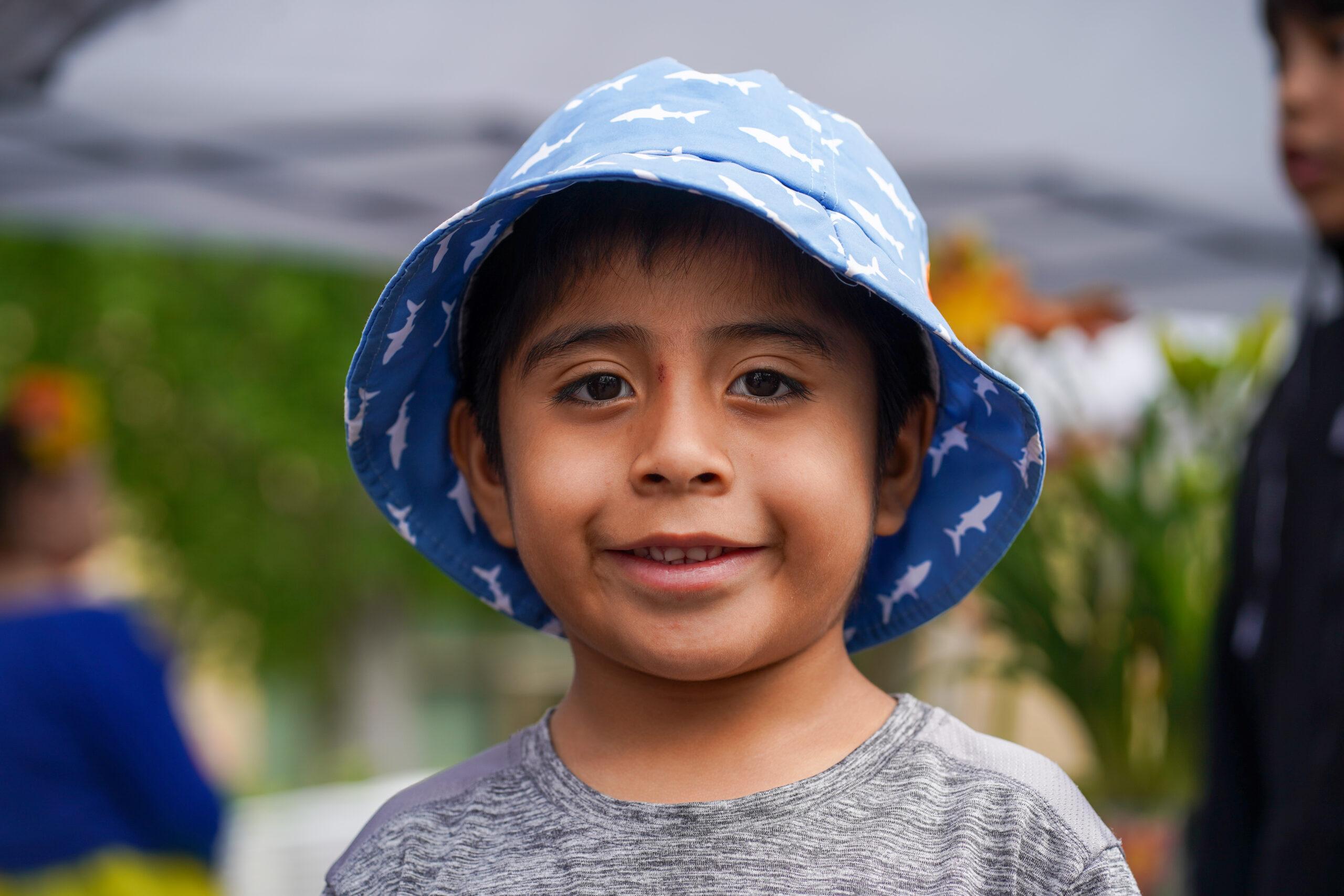 Joven con sombrero sonriendo a la cámara