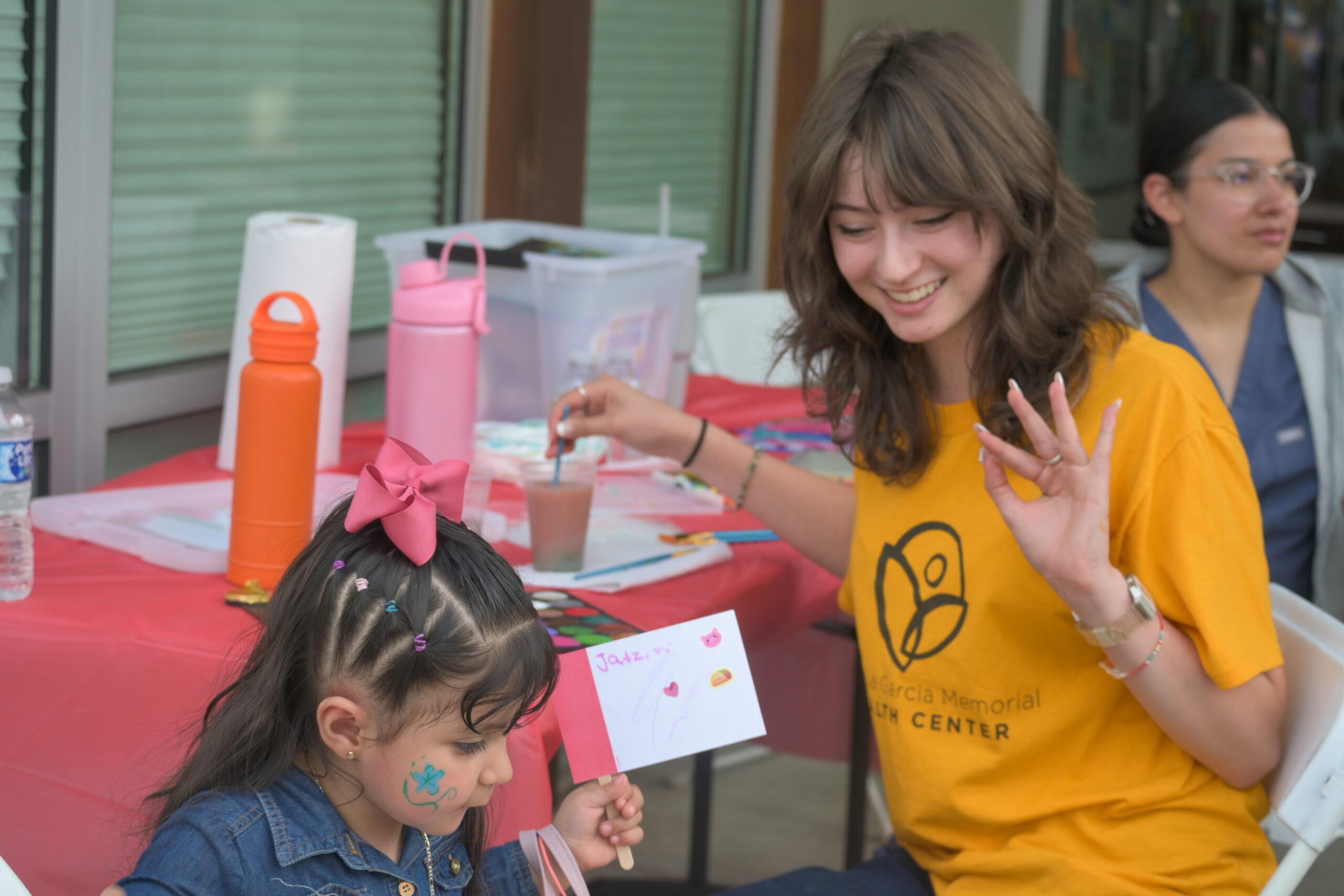 woman doing face paint on a child