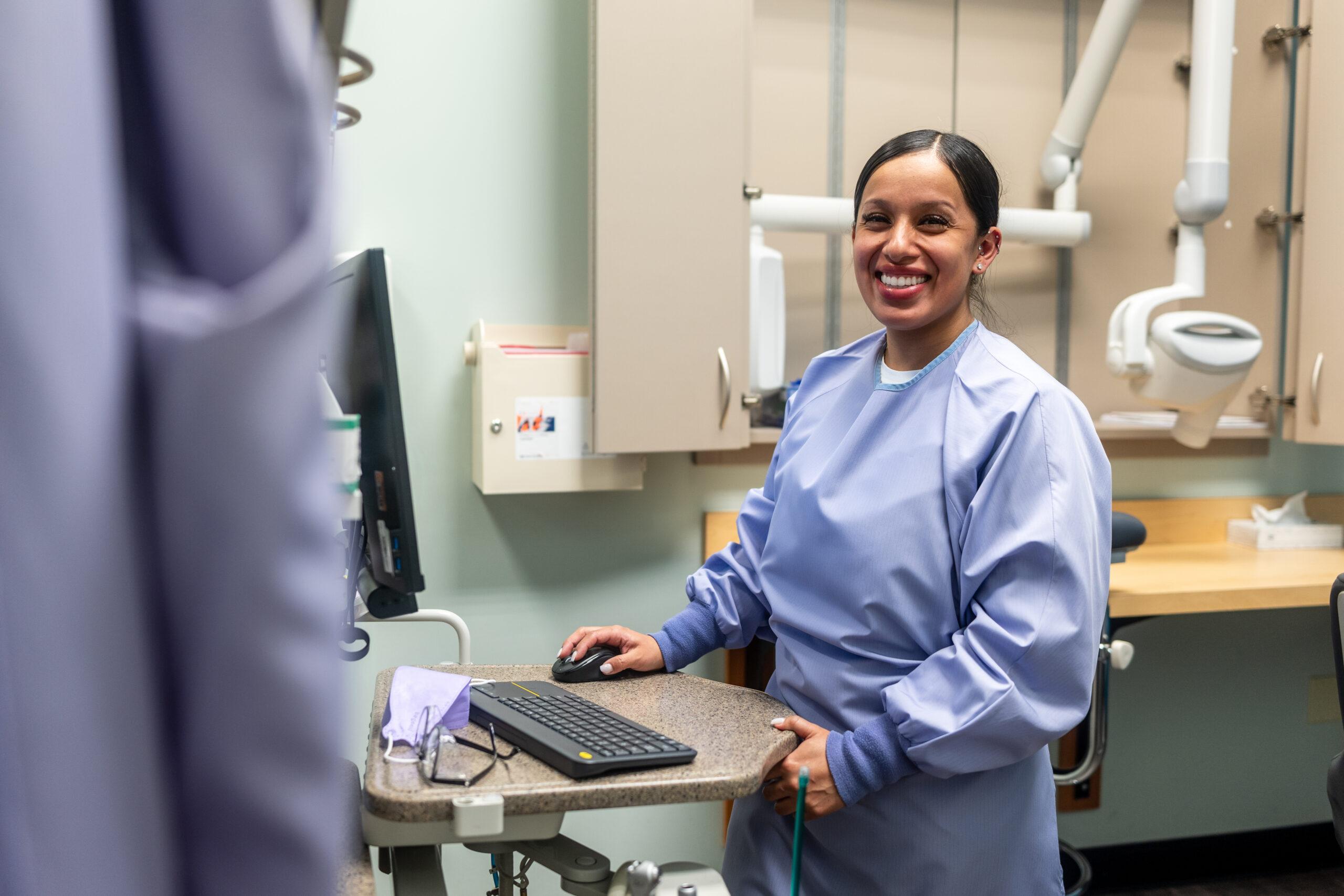 Medical professional at computer smiling
