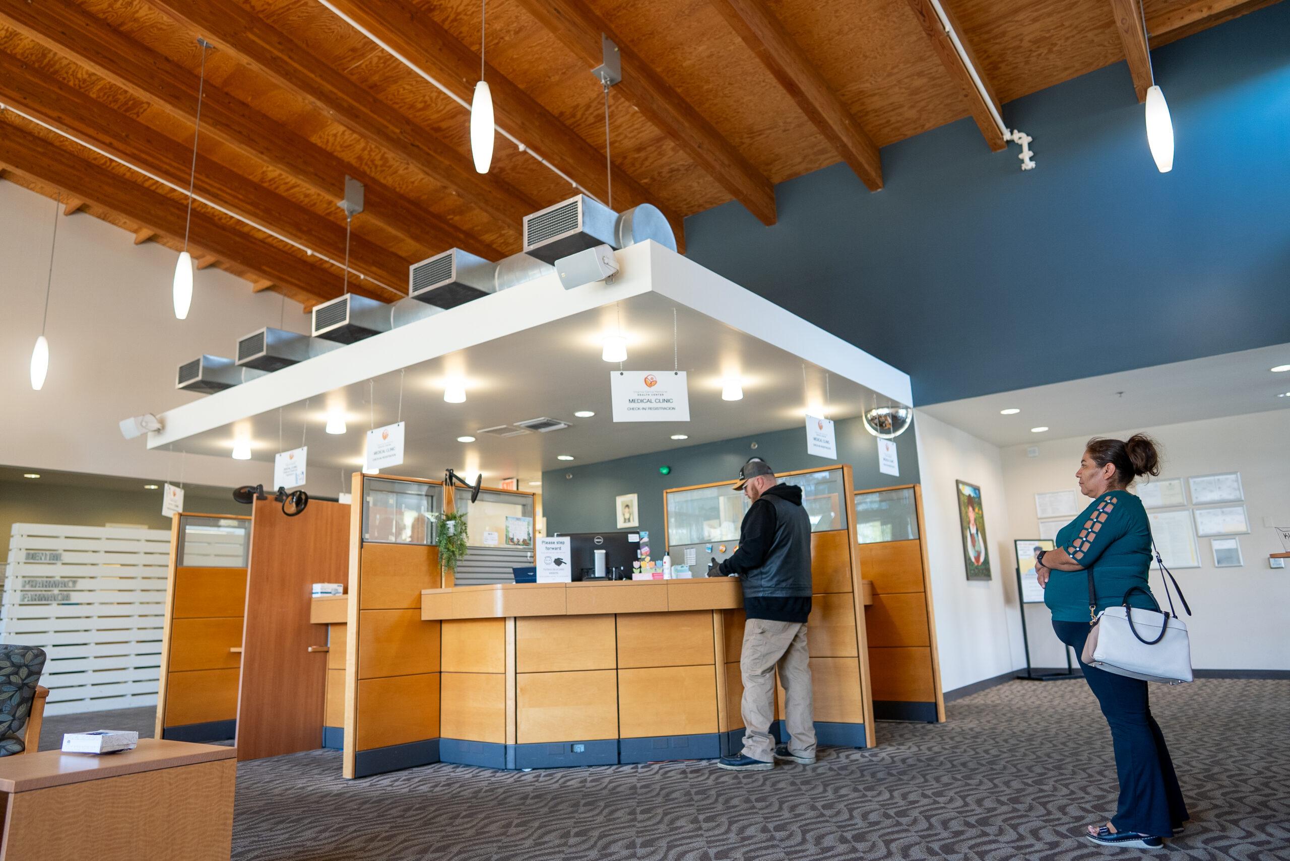 Inside of a medical building with individuals waiting in line